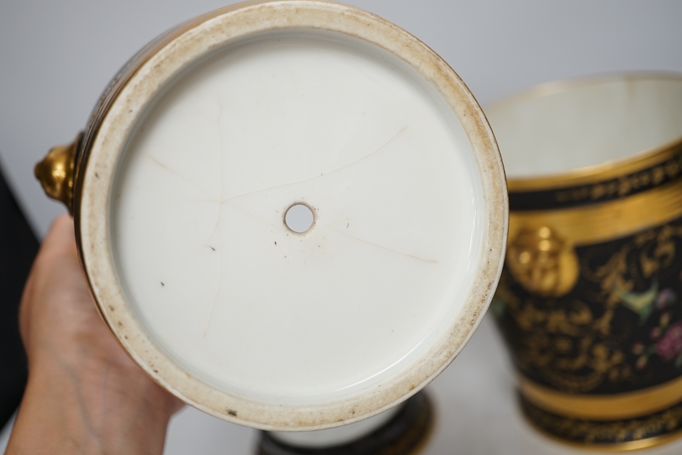 A pair of Paris porcelain cache pots and under dishes, black ground, floral and gilt decoration, 18.5cm high. Condition - both have wear to gilding and black ground, one pot has a star crack to base